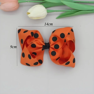 Détail d'un nœud papillon orange à pois noirs en ruban gros-grain, taille 14cm x 9cm