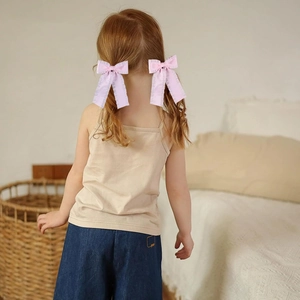 Detailed back view of pink ruffled ribbon bows with streamers on child's hair