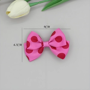 Detail van roze polkadot grosgrain lint haarstrik met afmetingen van 9 cm breed en 6,5 cm hoog