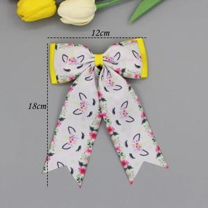 Floral unicorn print ribbon bow hair clip with long streamers and yellow edging detail