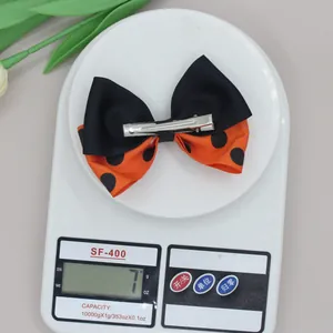 Détail de l'arrière d'un nœud papillon d'Halloween avec pince crocodile argentée sur une balance
