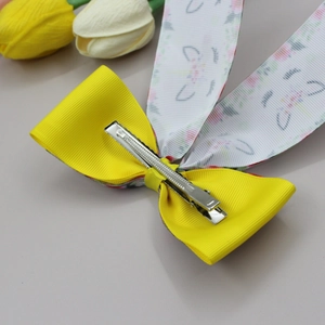 Elegant yellow ribbed bow hair clip with floral ribbon detail and silver metal duckbill grip
