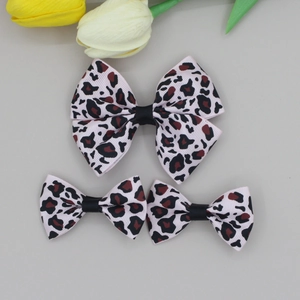 Detailed view of pink leopard print ribbon hair bows with black knot on gray background
