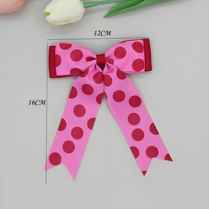 Detail van roze ripsband strik met rode stippen met de afmetingen 12 cm bij 16 cm