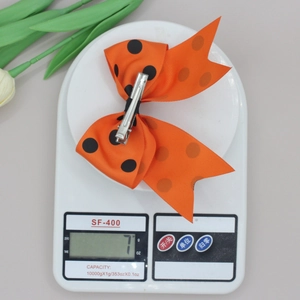 Gros plan d'un nœud papillon orange à pois de 7g sur une balance pour les accessoires
