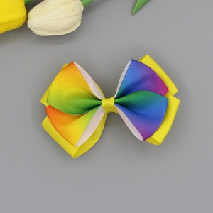 Detail view of a double-layered rainbow grosgrain ribbon butterfly hair clip with tulip decor