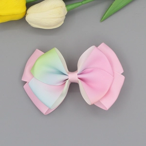 Detail of layered grosgrain ribbon hair clip with pink and rainbow gradient butterfly bow