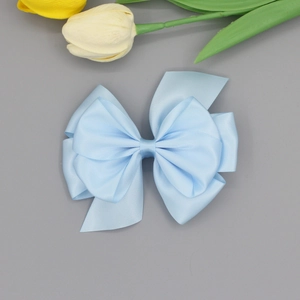 Close-up detail of light blue multi-layer satin silk bow hairpin accessory for women