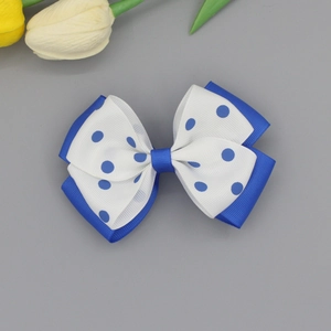 Detail of double-layered blue bow hair clip with white polka dots for girls