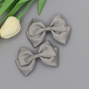 Detailed macro view of silver-grey grosgrain ribbon bows with elegant satin texture