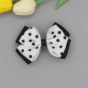 Double-layered butterfly hair clip with black ribbon and white polka dot pattern design