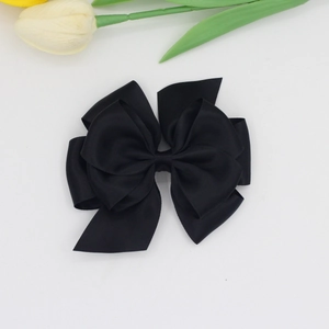 Close-up of a large black satin ribbon bow with multi-layered design and elegant texture