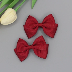 Detail view of red glitter ribbon bow hair clips with shimmering texture for girls