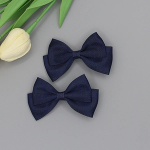 Close-up of navy blue layered grosgrain ribbon hair bows with fine fabric texture