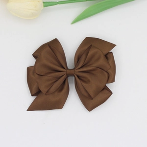 Close-up of elegant dark brown layered satin ribbon hair clip with silk texture