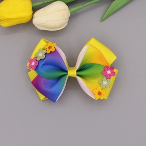 Detailed macro view of handmade grosgrain ribbon hair bow with small floral embroidery