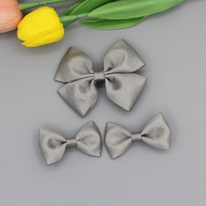Vue détaillée de nœuds à cheveux en satin gris argenté de tailles variées sur gris
