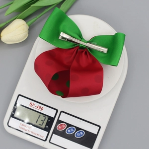 Détail d'une pince à cheveux de Noël en ruban pesée sur une balance numérique pour enfants