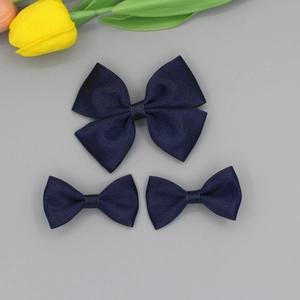 Vue détaillée de nœuds bleu marine pailletés à texture tissée avec décoration florale