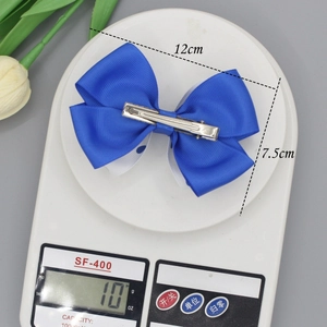 Royal blue double layer ribbon butterfly hair clip measured on scale at 12cm length