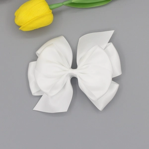 Detail of multi-layered white grosgrain ribbon hair bow with elegant symmetrical design