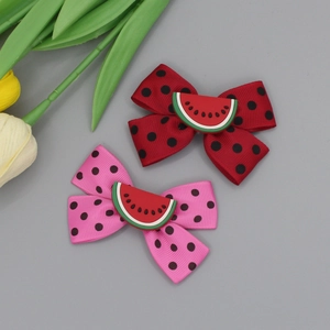 Detail of red and pink watermelon bow hair clips with polka dots and silicone charms