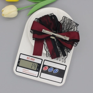 Lace bow hair clip in wine red and black weighing 14g on a digital scale