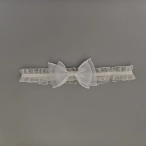 Vue détaillée du bandeau élastique en dentelle blanche avec un nœud en maille à double couche