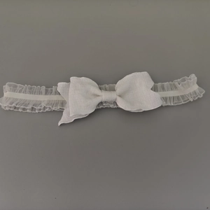 Gros plan détaillé du bandeau en dentelle blanche avec nœud élégant pour petites filles