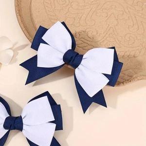 Close-up of navy and white grosgrain bow hair clip showing textured ribbon details