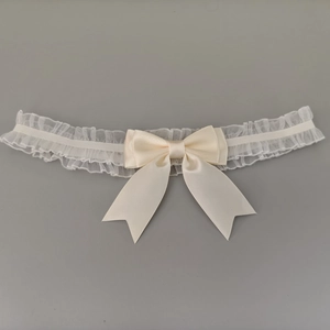 Vue détaillée du bandeau en dentelle blanc crème avec un nœud délicat en satin