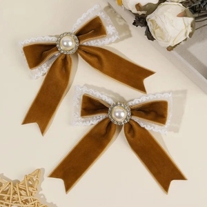 Detail of coffee velvet bow hair clip with faux pearl center and white floral lace