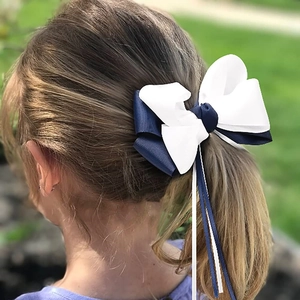 Classic navy and white grosgrain ribbon hair bow with long streamers on ponytail