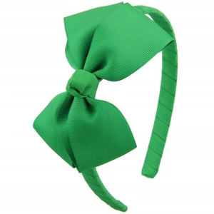 Close-up of grass green ribbed fabric headband featuring a large bow detail