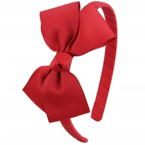Macro shot of large red ribbed fabric bow on a matching headband for young girls