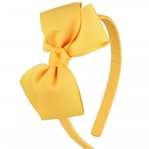 Detailed view of the bright yellow ribbed fabric texture on the girls' bow headband