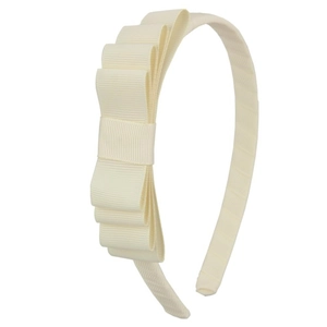 Detail of layered grosgrain ribbon bow on cream-colored headband for girls