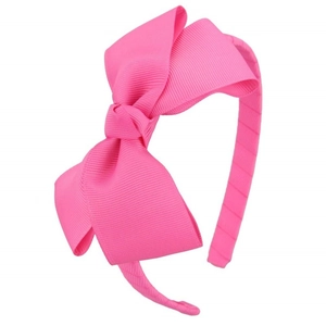 Close-up of bright fuchsia grosgrain ribbon texture on a large bow headband for girls