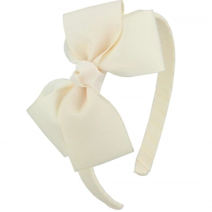 Detail shot of the ribbed texture and large bow on a cream white girls' headband