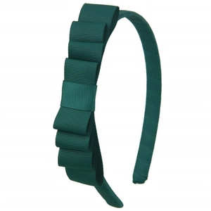Detail of dark green grosgrain ribbon layers and triple bow design on a children headband
