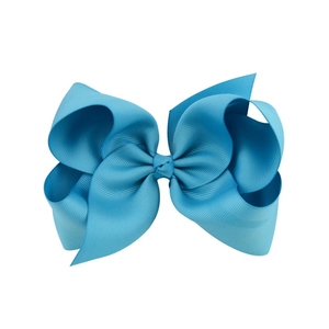 Macro detail of the light blue grosgrain ribbon bow with rich texture and layering