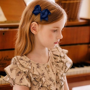 Barrette à nœud en ruban gros-grain bleu marine portée par un enfant, style vintage