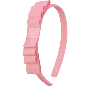 Detail view of pink multi-layered ribbon bow on a fabric-covered headband for girls