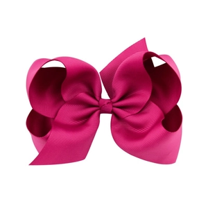 Macro shot of bright pink 6-inch grosgrain ribbon bow hair clip for young girls