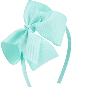 Détail du serre-tête nœud vert menthe en ruban gros-grain avec une texture côtelée chic