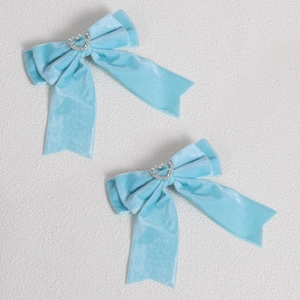 Détail de nœuds à cheveux en velours bleu ciel avec strass étincelants en forme de cœur