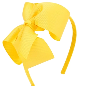 Gros plan d'un nœud en ruban gros-grain jaune de 5 pouces sur un serre-tête pour fille