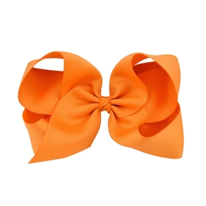 Detail of 6-inch orange grosgrain ribbon bow hair clip with ribbed texture for girls
