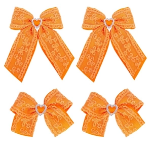 Detailed macro view of orange lace hair bows with ribbons and sparkling heart rhinestones