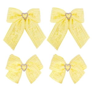 Detailed view of yellow lace hair clips with heart-shaped rhinestones and streamers
